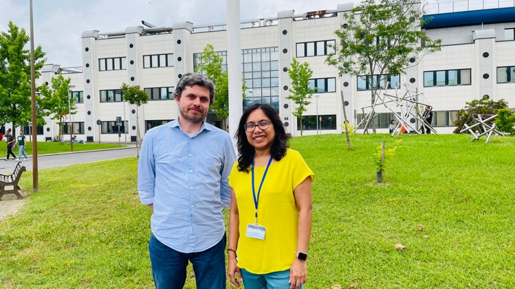 A person and person standing in front of a building
Description automatically generated